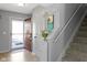 Inviting foyer featuring stairs, light-colored flooring, and a decorative cabinet with fresh flowers at 11741 Langham Crescent Ct, Fishers, IN 46037