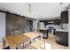 Modern kitchen with stainless steel appliances, a central island, and a wood dining table next to a decorative sliding barn door at 11741 Langham Crescent Ct, Fishers, IN 46037