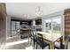 Well-lit kitchen with stainless steel appliances, dark wood cabinetry, a kitchen island and an adjacent wooden dining table at 11741 Langham Crescent Ct, Fishers, IN 46037