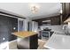Well-lit kitchen with stainless steel appliances, butcher block island, and dark cabinets at 11741 Langham Crescent Ct, Fishers, IN 46037
