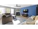 Well-lit living room featuring a cozy fireplace, sectional sofas, and large windows that let in natural light at 11741 Langham Crescent Ct, Fishers, IN 46037