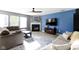 Cozy living room featuring a fireplace, comfortable sofas, large windows, and a view into the adjoining kitchen at 11741 Langham Crescent Ct, Fishers, IN 46037