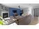 Inviting living room with a fireplace, blue accent wall, a comfortable sectional sofa, and light-colored flooring at 11741 Langham Crescent Ct, Fishers, IN 46037