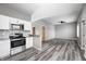 Bright kitchen area featuring white cabinets, gray backsplash, stainless steel appliances, and open to living area at 11975 Civic Cir, Mooresville, IN 46158