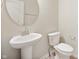 This powder room features a pedestal sink, brushed nickel faucet, and a round mirror at 12009 Jeff Ct, Noblesville, IN 46060