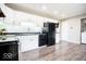 White cabinetry complements black appliances in this open kitchen with modern hardwood floors at 12566 S Hillview Dr, Columbus, IN 47201