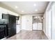 Open kitchen showcasing laundry area, white cabinets, black appliances, and sleek flooring at 12566 S Hillview Dr, Columbus, IN 47201