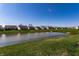 Community backyard with a pond, manicured lawn, and neighborhood houses at 1371 Blackthorne N Trl, Plainfield, IN 46168