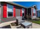 Home exterior featuring gray siding, red shutters, and outdoor seating area at 1371 Blackthorne N Trl, Plainfield, IN 46168