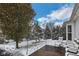 Winter view of backyard featuring patio seating amidst snow-covered trees and shrubs at 13982 Avalon Blvd, Fishers, IN 46037