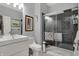 Modern bathroom featuring a sleek vanity, toilet, and a glass-enclosed shower with stylish gray tiling and fixtures at 14019 Colville Cir, Carmel, IN 46033