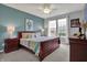 Charming bedroom featuring a cherry sleigh bed, light blue accent wall, and bright natural light from a double window at 14019 Colville Cir, Carmel, IN 46033