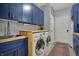 Laundry room features blue cabinetry, butcher block counters, and modern washer/dryer for convenience at 14019 Colville Cir, Carmel, IN 46033