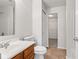 Bathroom featuring a wood vanity, white sink, toilet, and doorway to an adjacent closet at 14317 Banister Dr, Noblesville, IN 46060