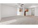 Open-concept living room with neutral carpet, a ceiling fan, and plenty of natural light at 14317 Banister Dr, Noblesville, IN 46060