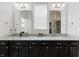 Bright bathroom boasting double sinks, granite countertops, dark cabinets, and modern fixtures at 1444 Waterleaf Dr, Westfield, IN 46074