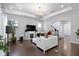 Spacious living room features white couch, large TV, fireplace, and hardwood floors at 1444 Waterleaf Dr, Westfield, IN 46074