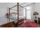 Primary bedroom featuring four-poster bed, dark wood floors, and a large window with natural light at 1444 Waterleaf Dr, Westfield, IN 46074