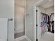 Elegant bathroom with a tiled shower and an open doorway into a well-organized closet at 1472 Windpump Way, Carmel, IN 46280