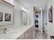 Bathroom featuring double sinks, modern fixtures, and wood look flooring at 1472 Windpump Way, Carmel, IN 46280