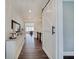 Hallway featuring dark wood floors, storage console, and barn door at 1472 Windpump Way, Carmel, IN 46280