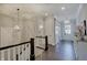Hallway with staircase and modern light fixtures with dark hardwood floors at 1472 Windpump Way, Carmel, IN 46280