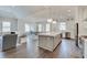 Spacious open concept kitchen with gray island, stainless appliances, and hardwood floors at 1472 Windpump Way, Carmel, IN 46280