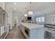 Open concept kitchen featuring stainless steel appliances, a large island, and easy access to living room and dining area at 1472 Windpump Way, Carmel, IN 46280