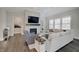 Cozy living room featuring a fireplace, TV, comfortable seating, and natural light from the windows at 1472 Windpump Way, Carmel, IN 46280