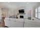 Bright living room features a stone fireplace, a large TV, a light grey paint scheme, and elegant furnishings at 1472 Windpump Way, Carmel, IN 46280