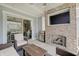 Inviting outdoor patio with brick fireplace, mounted TV, grill, and comfortable seating, perfect for relaxing and entertaining at 1472 Windpump Way, Carmel, IN 46280