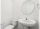 Powder room featuring a pedestal sink, toilet, and oval mirror at 1554 N Clearwater Dr, Greenfield, IN 46140
