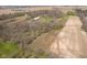 Expansive aerial view of a property with wooded areas, open fields, and buildings at 16471 E 196Th St, Noblesville, IN 46060