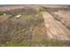 Wide aerial shot showcasing the property's layout with trees, fields, and outbuildings at 16471 E 196Th St, Noblesville, IN 46060