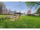 Large backyard with garden beds, a shed, and a blue house with a spacious deck at 16471 E 196Th St, Noblesville, IN 46060