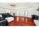 Large living room featuring hardwood floors, bay windows, and comfortable black leather seating at 16471 E 196Th St, Noblesville, IN 46060