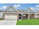Charming brick home with a two-car garage, green lawn, and stylish front porch at 19245 Red Willow Ln, Noblesville, IN 46062