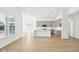 Inviting open-concept living space showcasing a modern kitchen with hardwood floors and ample lighting at 19245 Red Willow Ln, Noblesville, IN 46062