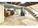 Unfinished basement area with washer/dryer hookups, staircase, and open ceiling at 2050 Winton Ave, Indianapolis, IN 46224