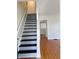 Entryway featuring carpeted stairs with white banister and wood floors leading into another room at 2050 Winton Ave, Indianapolis, IN 46224