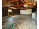 Spacious garage interior with concrete floor, exposed rafters, and a white garage door at 2050 Winton Ave, Indianapolis, IN 46224
