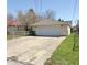 Detached garage with a large driveway and plenty of parking space, set against a blue sky backdrop at 2050 Winton Ave, Indianapolis, IN 46224