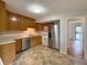 A view of the kitchen including stainless steel appliances, tiled floor, and wooden cabinets at 2050 Winton Ave, Indianapolis, IN 46224