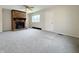A spacious carpeted living room including brick fireplace and ceiling fan at 2050 Winton Ave, Indianapolis, IN 46224