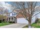 Charming two-story home featuring a brick facade, white siding, a two car garage, and mature trees at 2236 Willowview Dr, Indianapolis, IN 46239
