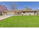 Charming ranch-style home with stone facade, attached garage, and well-manicured lawn at 2329 E 8Th St, Anderson, IN 46012