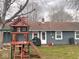 Backyard with a swing set, grass, mulch, and mature trees at 2517 Horton Dr, Anderson, IN 46011