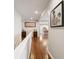 Upper hallway with hardwood floors and view of the kitchen, enhanced by decorative artwork at 267 Westbrook Ct, Columbus, IN 47201