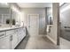 Bathroom featuring double sinks, white cabinets, granite countertops, and a glass enclosed shower at 2779 Ruffian Dr, Westfield, IN 46074