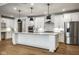 Bright kitchen boasts white cabinetry, stainless steel appliances, a large island, and hardwood flooring at 2779 Ruffian Dr, Westfield, IN 46074